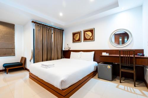 a bedroom with a bed and a desk and a mirror at XX YON INN Sukhumvit 4 Bangkok - BTS Nana in Bang Kapi