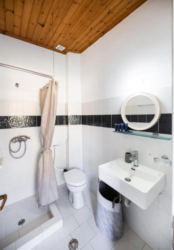 a white bathroom with a sink and a toilet at Pansion Margarita in Agios Nikitas