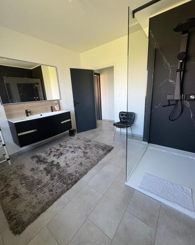 een badkamer met een bad, een wastafel en een spiegel bij L'échappée verte in Sailly