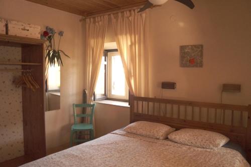 une chambre avec un lit, une chaise et une fenêtre dans l'établissement House Eleni, à Sikia