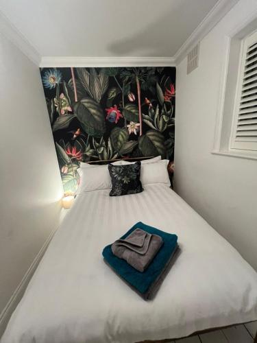 ein Schlafzimmer mit einem Bett und einem Handtuch darauf in der Unterkunft Life's A Beach - cosy, luxury cottage in Ashley Cross, Poole in Parkstone