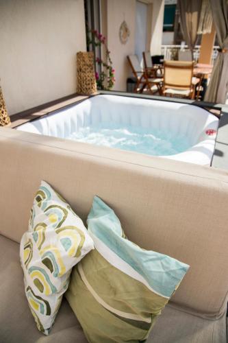 a jacuzzi tub with a pillow on a couch at Gk Suites-Constantin view , auto check-in 24h in Larisa