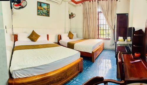 a hotel room with two beds and a desk at royal hotel bà điểm hồ chi minh in Ho Chi Minh City