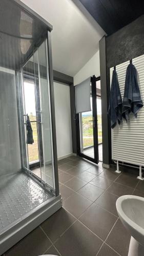 a bathroom with a glass shower and a sink at Casa Ranio in Topliţa