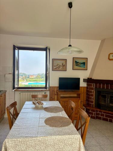 una sala da pranzo con un tavolo e una televisione di La Casetta nel Cortile ad Appiano Gentile