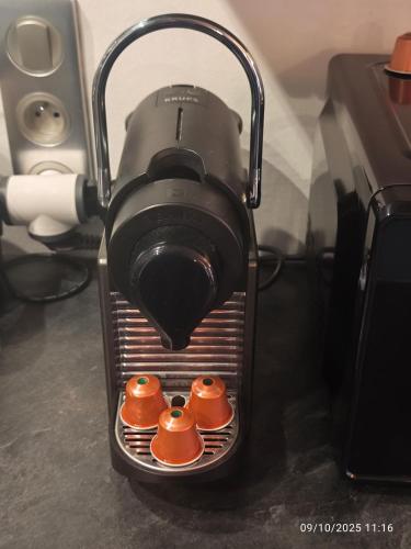 a coffee maker with four tea cups in it at Maison de village chaleureuse avec terrasse 3 étoiles in Serrières-en-Chautagne
