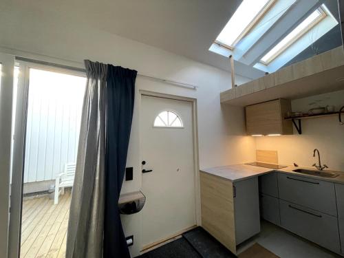 a kitchen with a sink and a door with a window at Guesthouse at Roland's in Uppsala