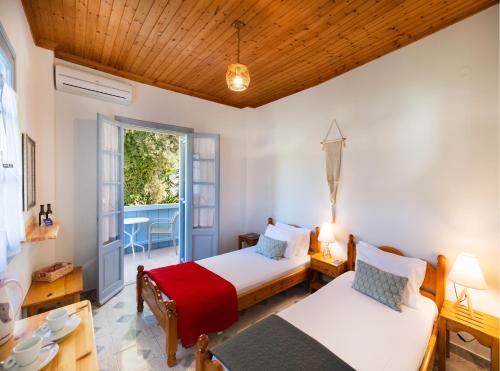 a bedroom with two beds and a table at Pansion Margarita in Agios Nikitas
