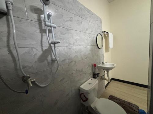 a bathroom with a shower with a toilet and a sink at Albatina Place in Nakasongola