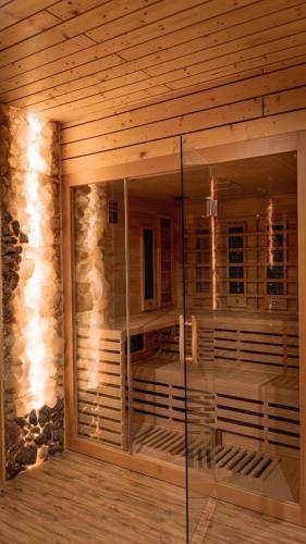 a room with a glass shower in a wooden wall at Stone Suite Zakopane in Zakopane