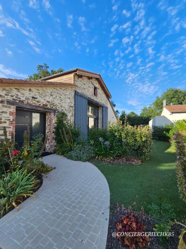 una casa di mattoni con un passaggio pedonale davanti al cortile di Le Petit Loup grande maison de charme en campagne a LʼOie