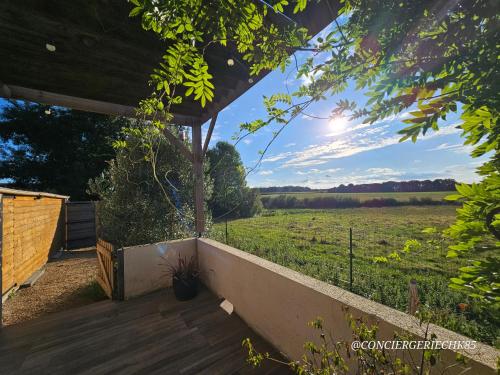 una veranda in legno con vista su un campo di Le Petit Loup grande maison de charme en campagne a LʼOie