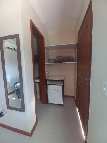 a room with a mirror and a closet with a door at Pousada Caminho do Mar in Torres