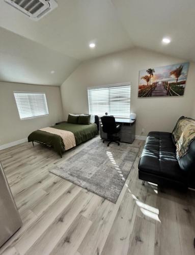 a bedroom with a bed and a couch and a desk at The studio for all your needs in Sacramento