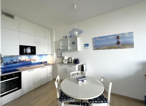 a kitchen with a table and a kitchen with a lighthouse at Se 06 Haus Seeterrassen in Cuxhaven