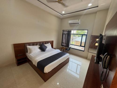 une chambre avec un lit et une télévision dans l'établissement Hotel Vasudev- near Toran Gate, à Khātu
