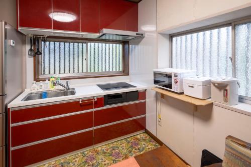 a small kitchen with a sink and a microwave at 甲府木ノ間Kofu Konoma in Kofu