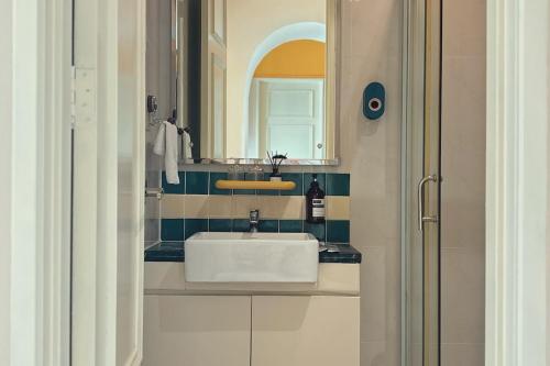 a bathroom with a white sink and a mirror at Dooga Ins-Retro Opera Deco Seaview Bathtub by Doogahome Homestay in Johor Bahru