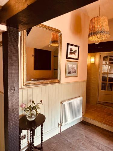 a room with a mirror and a table and a television at The Eight Bells Inn, Bolney in Bolney