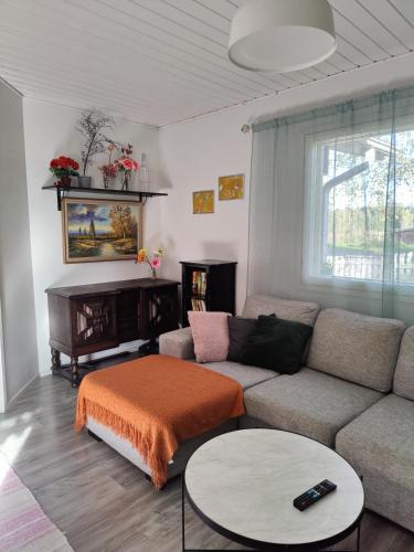 una sala de estar con un sofá y una mesa en Koivistonpiha farmstay, en Valkeakoski