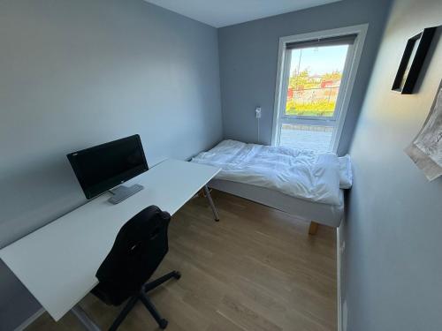 ein Zimmer mit einem Schreibtisch und einem Bett mit einem Computer in der Unterkunft Luksuriøs enebolig, nær Ålesund in Ytterland