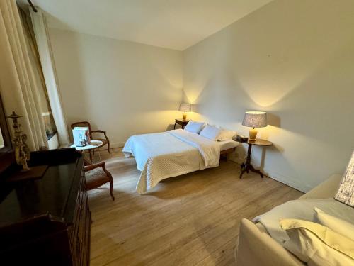 a bedroom with a bed and two tables and a couch at Maison Mǔso in Dinant