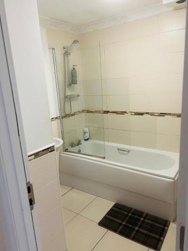 グラスゴーにあるMaster Bedroom in City Centerの浴槽とシャワー付きの白いバスルーム