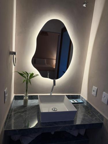 a bathroom with a sink and a mirror at Pousada Maritaca in Bonito