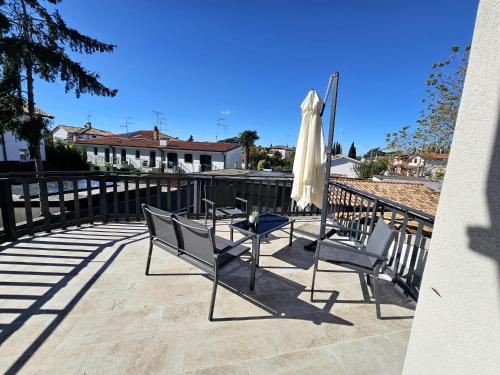 a patio with two chairs and an umbrella and a table at Villa Kristin Residence in Monfalcone