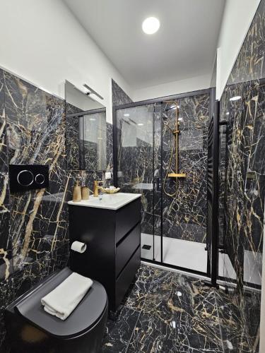 a black bathroom with a sink and a shower at Villa Kristin Residence in Monfalcone