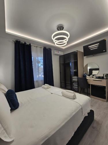 a bedroom with a large white bed and a desk at Villa Kristin Residence in Monfalcone