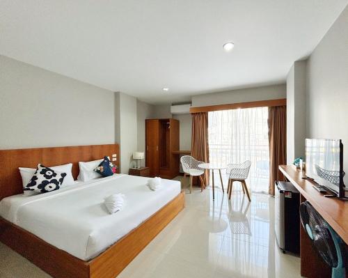 a bedroom with a large bed and a dining room at The Brown Boutique Patong in Patong Beach