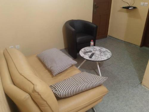 a room with a couch and a chair and a table at Séjour Plus Bénin in Cotonou Cadjehoun
