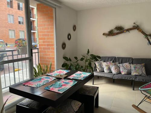 una sala de estar con una mesa y un sofá en Apartamento en clima caliente, en Apulo