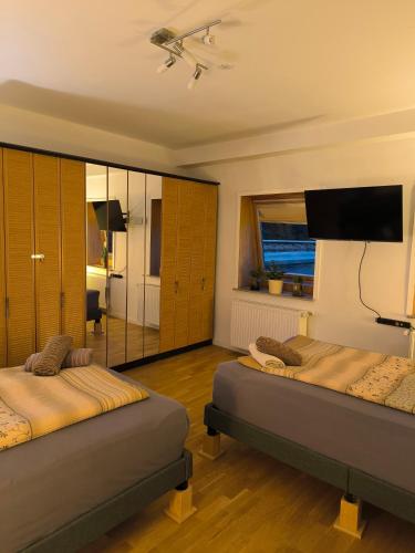 una camera da letto con due letti e una TV a schermo piatto di AufmLohr - Appartement mit 3 Schlafzimmern- 4 Einzelbetten- für 4 Personen - in Leverkusen Hitdorf - Private Parkplätze vorhanden- a Leverkusen