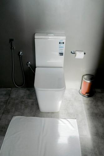 a white toilet in a bathroom with a shower at Sundowners in Chilaw