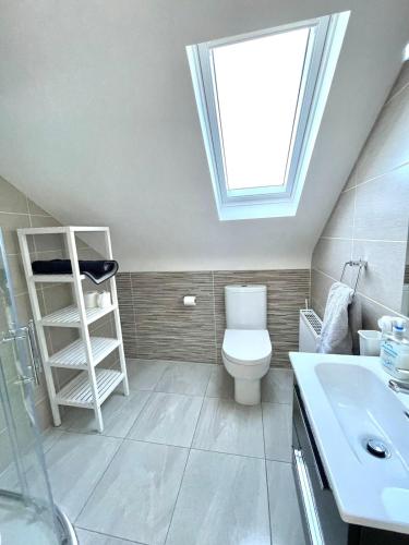 a bathroom with a skylight and a toilet and a sink at Rossnowlagh Waves Lodge in Rossnowlagh