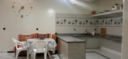 a kitchen with a table and chairs and a counter at شقة في موقع سياحي لمحبي المناظر الخلابة وشلالات in Beni Mellal