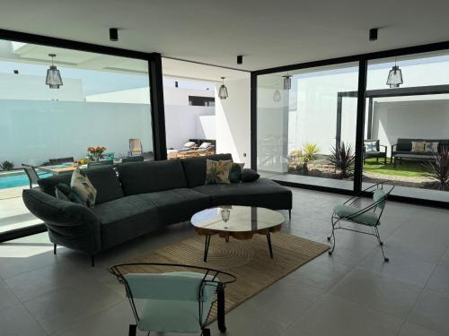 a living room with a couch and a table and chairs at Stylish and comfortable Villa Anna in Villaverde in Lajares