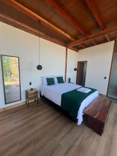 a bedroom with a large bed and a wooden floor at Reserva Cipó in Serra do Cipo