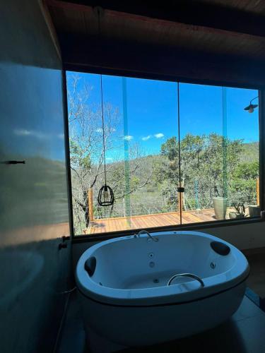 a bath tub in a room with a large window at Reserva Cipó in Serra do Cipo