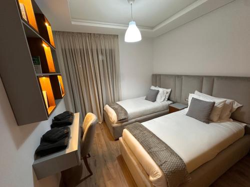 ラバトにあるLuxury and comfort close to TGV stationのベッド2台とソファがあるホテルの部屋