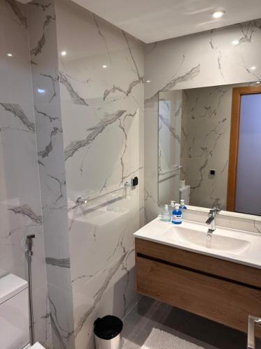 ラバトにあるLuxury and comfort close to TGV stationの大理石の壁のバスルーム(シンク付)