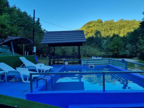 a swimming pool with chairs and a gazebo at Dolina Mira in Srebrenik