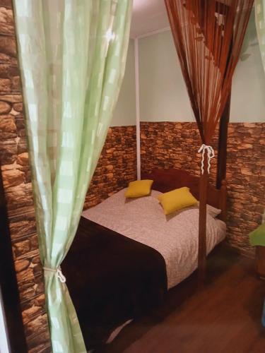 a bedroom with a bed with yellow pillows at Sunny Side Fruska Gora- apartman A in Velika Remeta
