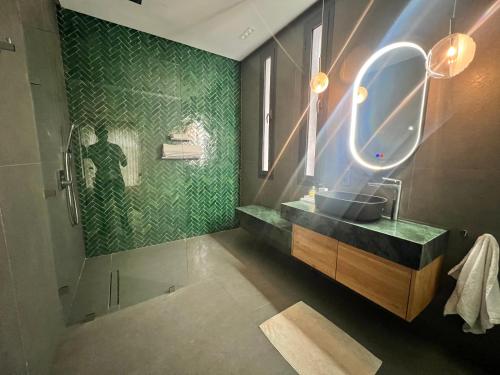 a bathroom with a sink and a shower with a mirror at Villa prestige in Essaouira