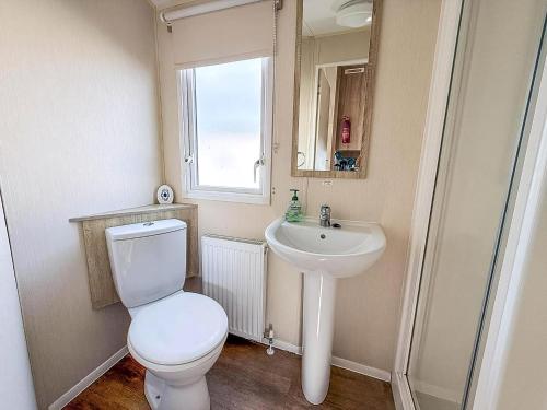 a bathroom with a toilet and a sink at Great Caravan With Central Lounge & Wifi At Broadland Sands, Suffolk Ref 20070Bs in Hopton on Sea