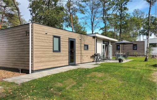 a small wooden house with a grass yard at Amazing Home In Hellendoorn With Sauna in Hellendoorn
