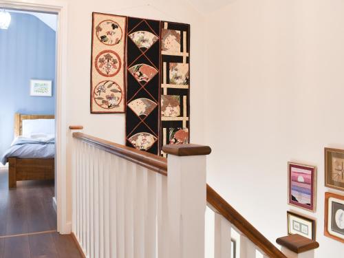 a hallway with a staircase with plates on the wall at White Heather Barn in Swanwick