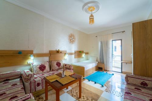 una sala de estar con un sofá y una cama en Anna Surf house Tamraght, en Aourir
